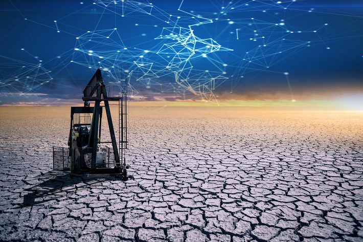 Oil rig in the desert on a background of a dramatic sky. Symbol