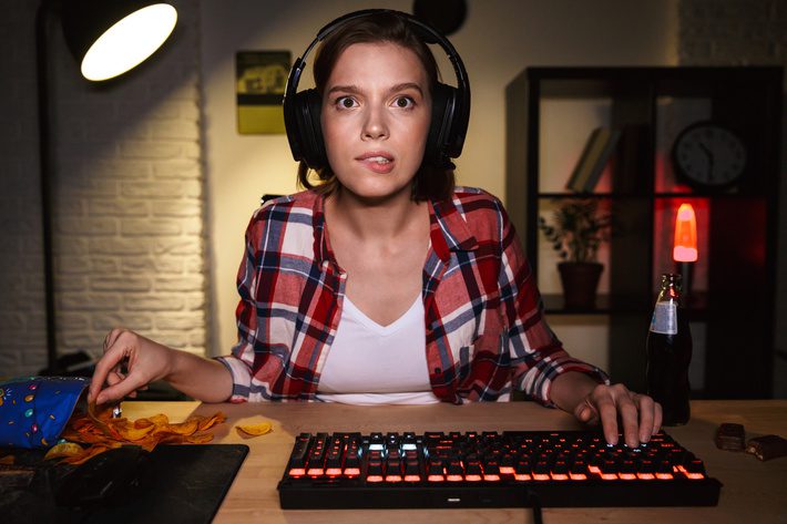 Excited girl wearing headset playing online games