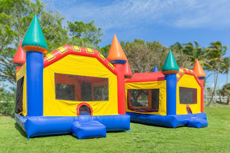 Two multi-color castle bounce houses are ready for the kids.