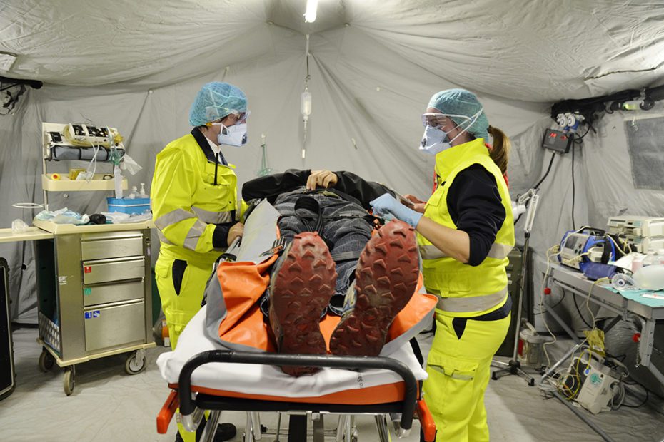 Alert pandemic Covid-19. Doctors with protective masks assist a