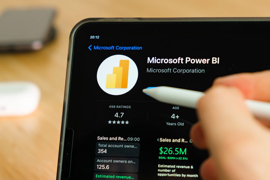 Microsoft Power BI logo shown by apple pencil on the iPad Pro tablet screen. Man using application on the tablet. December 2020, San Francisco, USA.