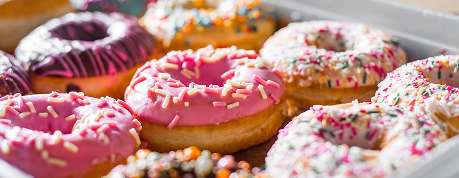 Assorted sweet donuts in a paper box.