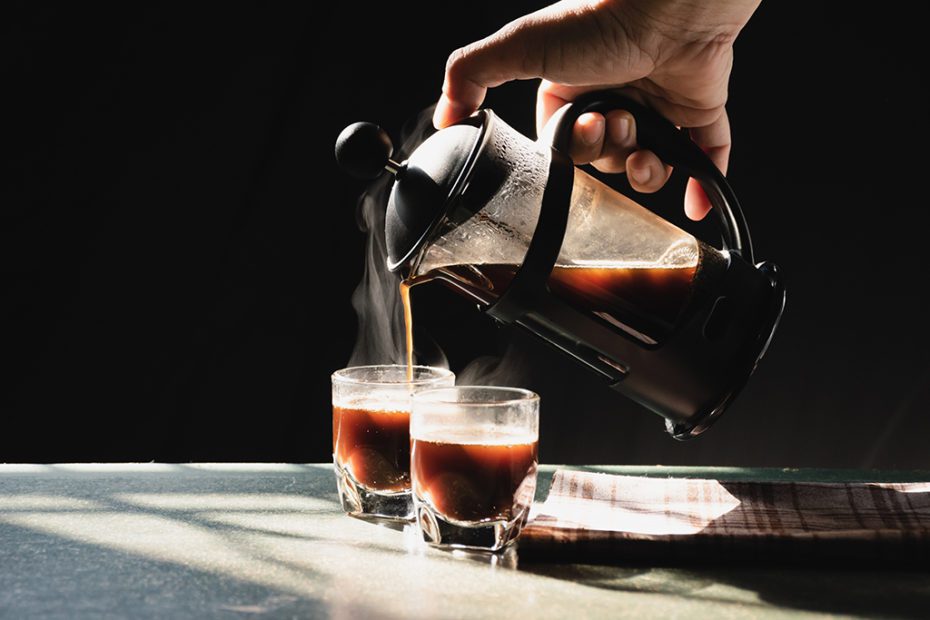 Aromatic coffees with hot smoke are poured into couple cup from