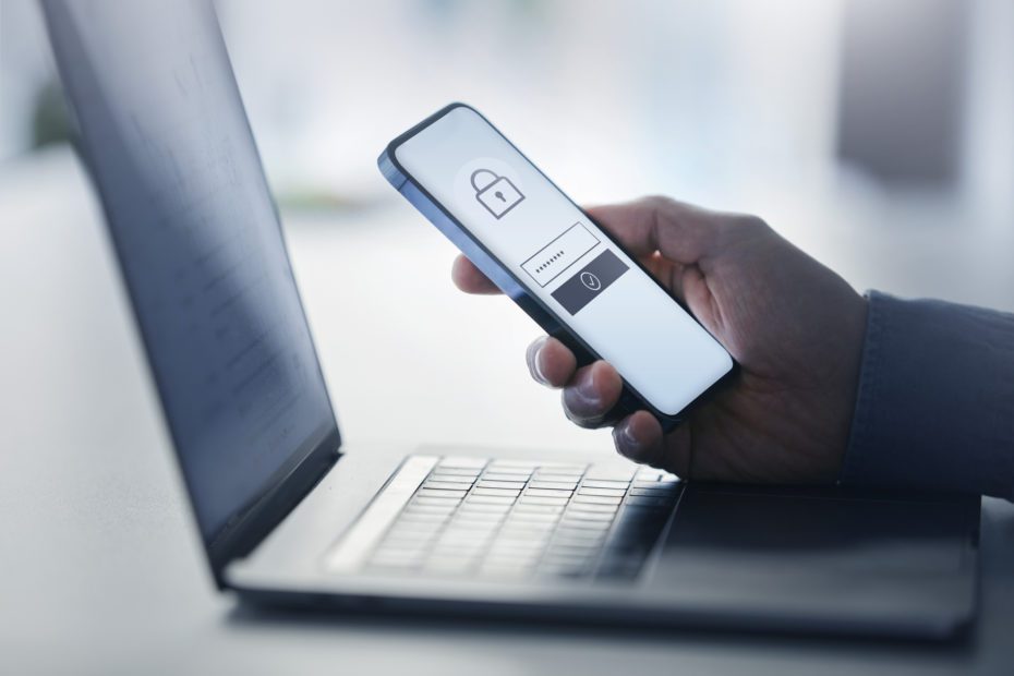 Man holding smart phone with data security on display at office