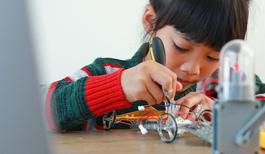 The little girl asian building robotic car in science lesson in
