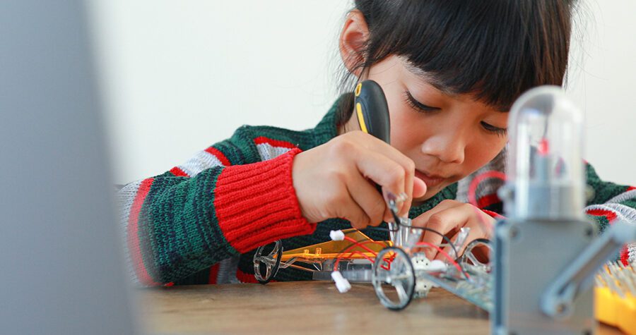 The little girl asian building robotic car in science lesson in