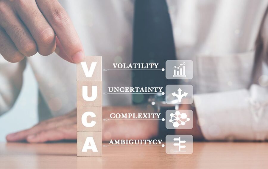 VUCA and strategic management. Hand puts wooden cubes with VUCA
