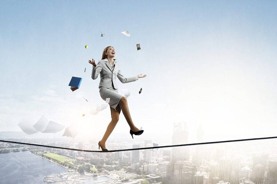 Young pretty businesswoman juggling with business items