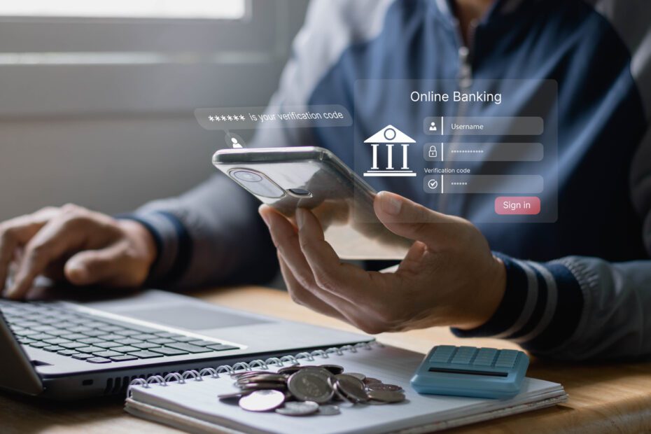 cyber security and two-step verification concept. Online Payment Internet Banking Concept. Man’s hands are holding mobile smartphone making Online shopping and payment with a laptop computer.